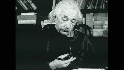 1940s: Albert Einstein makes notes and smokes pipes. Sir James Chadwick sits at Stock Footage 153554073