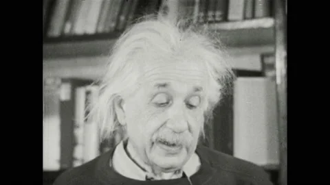 1940s: Albert Einstein stands near bookshelf and speaks. Stock Footage 169234134