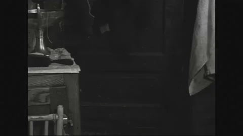 1940s: In the apartment room, various items adorn the table and dresser, while Stock Footage 161805554