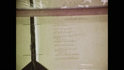1940s: Articles of surrender lie in glass case on display. Embossed metal plaque Stock Footage 154042938
