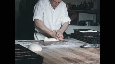 1940s: Baker rolls out dough and places it in bread pans. Hand holds diseased Video stock 170458928