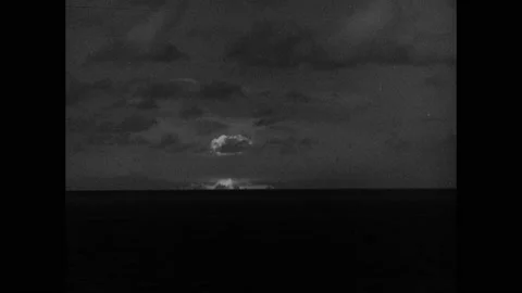 1940s Bikini Atoll: Atomic bomb explodes on horizon and mushroom cloud climbs 動画素材 148223653