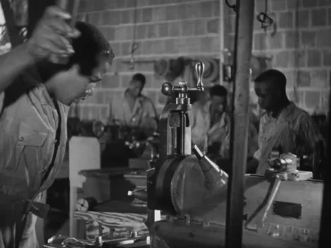 1940s: Black man uses machine under supervision Stock Footage 229754511
