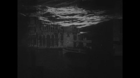 1940s: Boats float along the canals of Venice, Italy. Train rolls down tracks Stock Footage 127716207