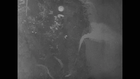 1940s: Bombs drop on Tokyo from bomber planes in sky. Bombs explode on ground Stock Footage 159170014