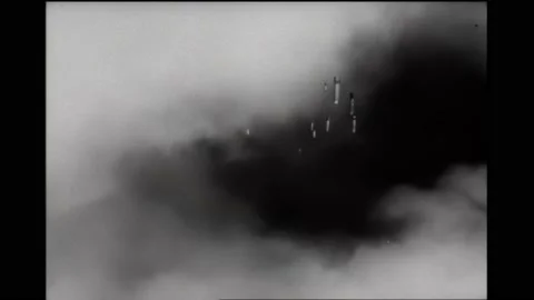 1940s: Bombs dropping through the clouds. Gun turret. Gunner firing a machine Stock Footage 165115523