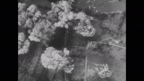 1940s: Bombs explode on ground. Bombs fall from plane. Gun ships fire cannons. Stock Footage 137411497
