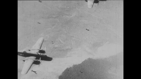 1940s: Bombs fall from warplanes. Building on mountaintop explodes. Soldiers  Stock Footage 126014824