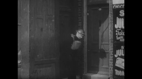 1940s: Bombs hits building in London. Patrol man runs as bombs hit. View from Stock Footage