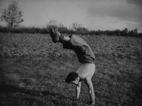 1940s: Boy doing handstand in field Stock Footage 229735498