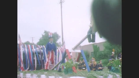 1940s: Boy dressed as Uncle Sam stands on parade float. Men sit on side of Stock Footage