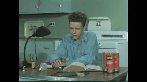 1940s: Boy sat next to Bright Star Industries dry cells at kitchen table. Boy Video stock 195118529