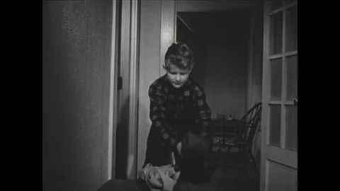 1940s: Boy takes clothes out of closet / Close up, hands pile winter clothes / Stock Footage