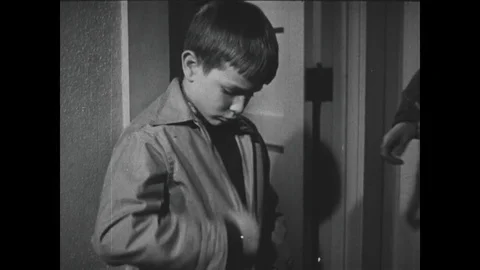 1940s: Boy zips up coat / Girl straps on boots / Close up, hands close straps / Stock Footage