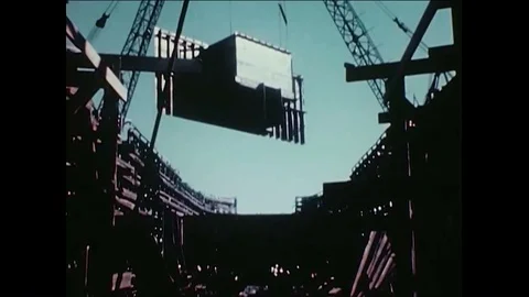 1940s - Bulkheads and side shells are lowered onto a ship mid-construction. 스톡 동영상 86407367