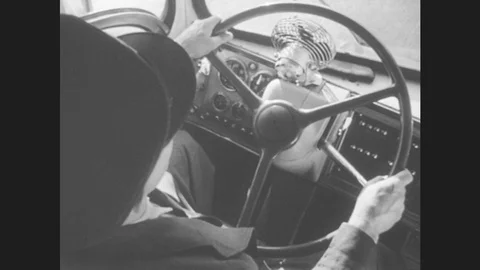 1940s: Bus driver hold steering wheel, drives bus. Bus drives down highway, Stock Footage 79100600