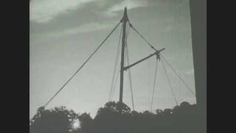 1940s: Cable structure. Man works on boat. Boat docked at harbor Stock Footage 78247875