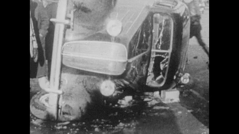 1940s: Car lays on side, windshield smashed. People fight, newspaper headlines Stock Footage