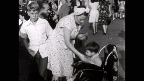 1940s: Child in a stroller on the boardwalk throws a tantrum. Parachute jump Stock Footage 220241037