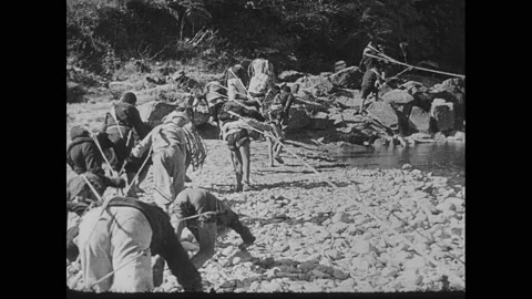 1940s China: People pull cargo and boats up river. Stock Footage 138337734
