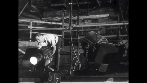 1940s: Cinematographer Sets Up Lighting on Film Set Stock Footage 74873246