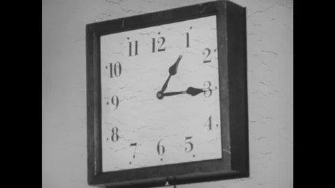1940s: Clock on wall reads 1:15pm. Clock jumps forward to 1:25pm. Boy sits at Stock Footage 118146150