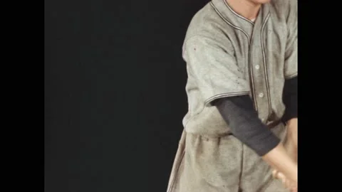 1940s: Close up of baseball player's arms swinging bat. Player swings bat. Stock Footage