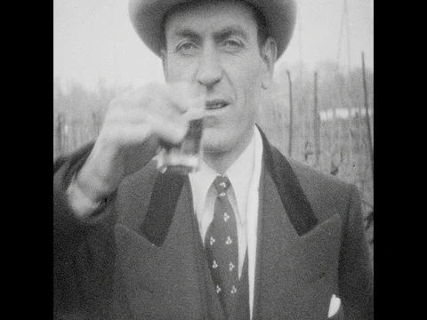 1940s: Close ups of man drinking from glass. Man holds up piece of paper. Men Stock Footage 82927973