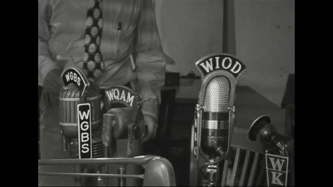 1940s - Close-ups from various angles show a radio newsman reading a report on Stock Footage 124508943
