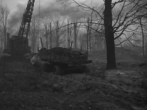 1940s: Dragline excavator pulls flatbed truck Stock Footage 231425574