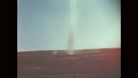 1940s: Dust devil in field. Muddy water flows down river. Tree falls over. Stock Footage 80266431