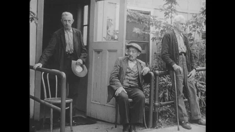 1940s: Elderly men outside building / Man in chair / Men on beds in farm colony Vídeos de archivo 74685369