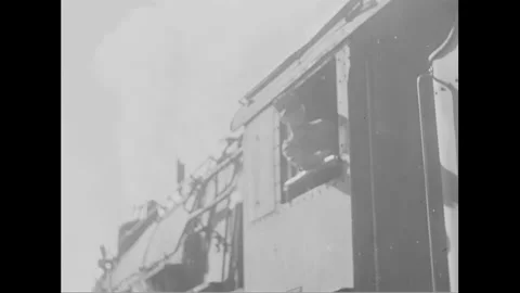 1940s: An engineer, peering out of a steam train's window, watches as the Stock Footage 156513549