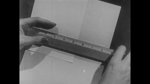 1940s: Envelope being measure against a piece of paper. Stock Footage 253354092
