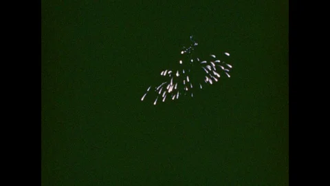 1940s: Fireworks explode in night sky; small squibs of fire leap from barge, Stock Footage 86660925