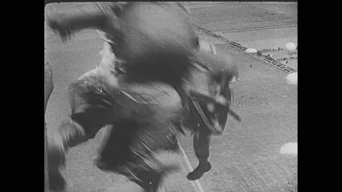 1940s: Flying in sky, explosions on ground. Soldiers parachute from plane. Fleet Stock Footage 144714967