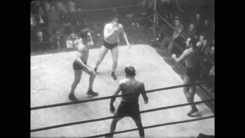 1940s: Four wrestlers brawl in ring. Wrestlers form headlock chain in ring. Vídeo Stock 160573379