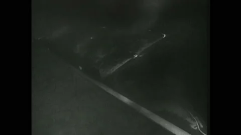 1940s Germany: Explosions light up hillside. Broken bridge over river. Trucks Stock Footage 143687090