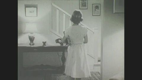 1940s: Girl walks up stairs. Man speaks to lady Stock Footage