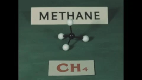 1940s: A hand holds a model of a methane molecule, with a card labeled CH4 Stock Footage 280687939