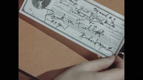 1940s: Hand holds promissory note. Colored blocks balance table scale with Stock Footage 168630804