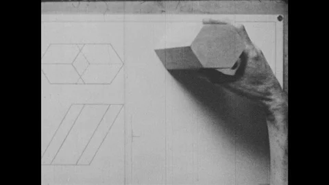 1940s: A hand takes a hexagonal prism, matches it with projection of solid on Stock Footage 94220505