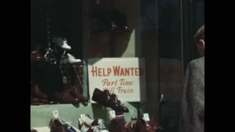 1940s: Help Wanted Part Time sign in shop window. Shoe shop window. Man looks at Vidéo 195299859