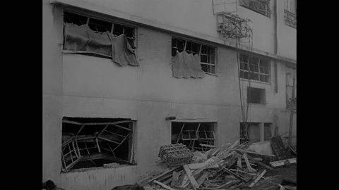 1940s: Hiroshima.  Building with blown out windows.  Man traces lines on chair.  Stock Footage 158443716