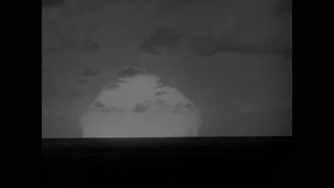 1940s: Horizon of ocean. Atomic explosion occurs on horizon, giant mushroom Stock Footage 150342314