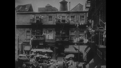 1940s: Housing and court yard. Group of children holding hands and walking. Men Stock Footage