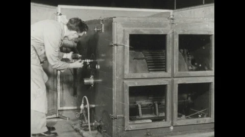1940s: Lab, motor in test chamber, man adjusts knobs, pulls lever, drum 스톡 동영상 116861358