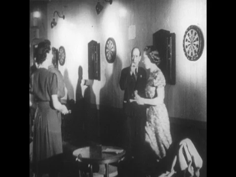 1940s: ladies play darts. Soldiers walk across land. Men patrol moors. Stock Footage