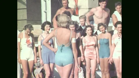 1940s: Lady models swimsuit. Ladies on stage. Person dives into swimming pool Stock Footage