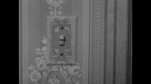 1940s: Light switch, dissolve, switch plate is removed. View of electical Stock Footage 122513945